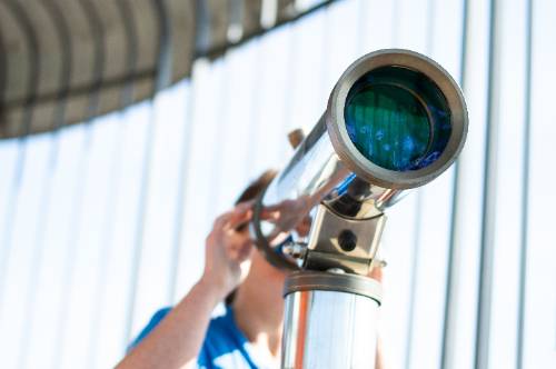 woman looking through a telescope