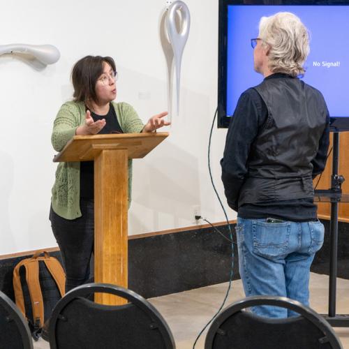 Kayla Ohlmer talks with an attendee at her exhibits reception.