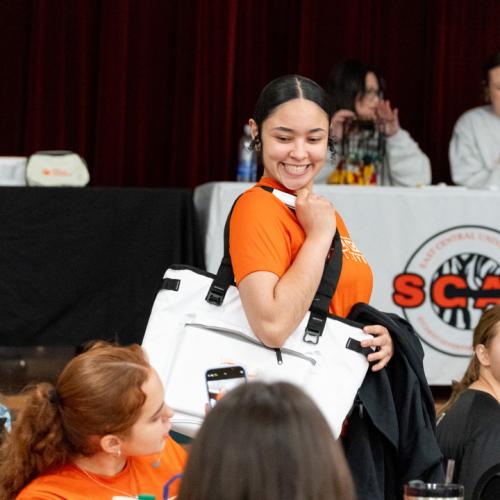 A student shows off her new ECU Tigers cooler bag to her friends.