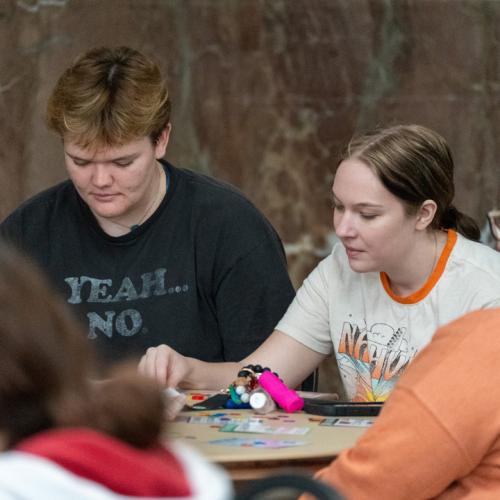 Two students scan their bingo cards waiting for their numbers to be called out.