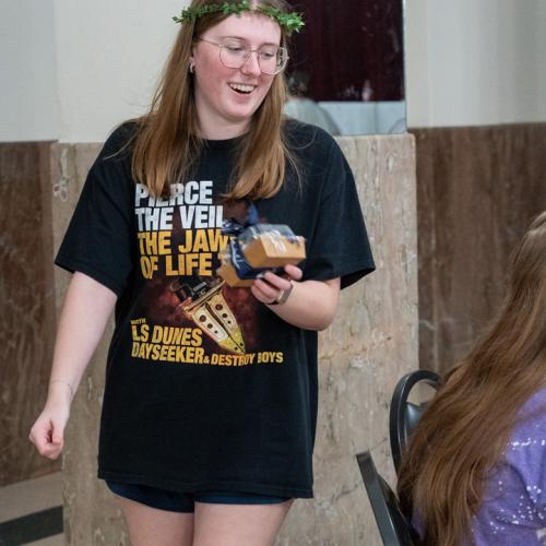 A student returns to her table happy with her prize after winning a round of bingo.