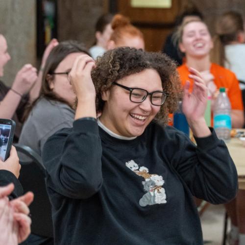 A girl wins a 40 inch TV in the final round of Lucky Tiger Bingo with a blackout and other students cheer for her.