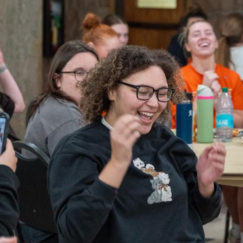 A girl wins a 40 inch TV in the final round of Lucky Tiger Bingo with a blackout and other students cheer for her.