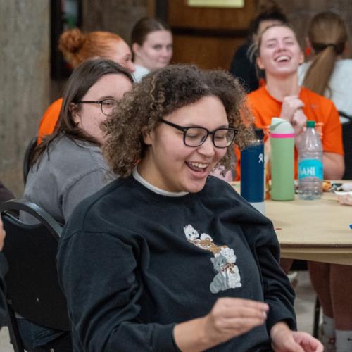 A girl wins a 40 inch TV in the final round of Lucky Tiger Bingo with a blackout and other students cheer for her.