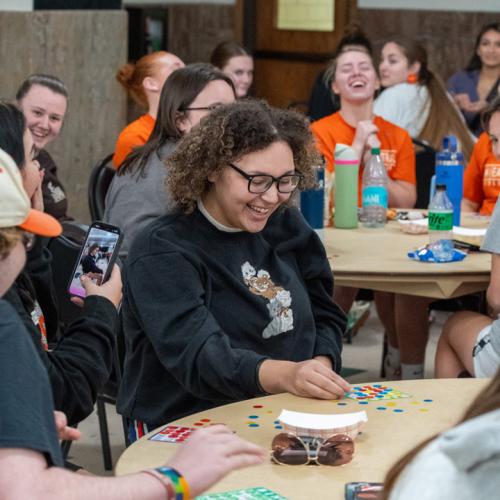 A girl wins a 40 inch TV in the final round of Lucky Tiger Bingo with a blackout and other students cheer for her.